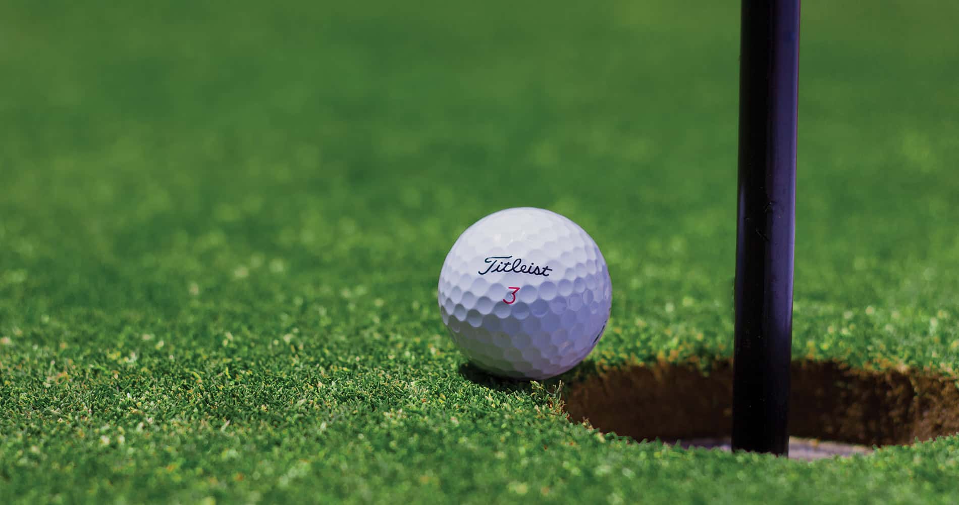 Balle de golf près du trou sur le green.