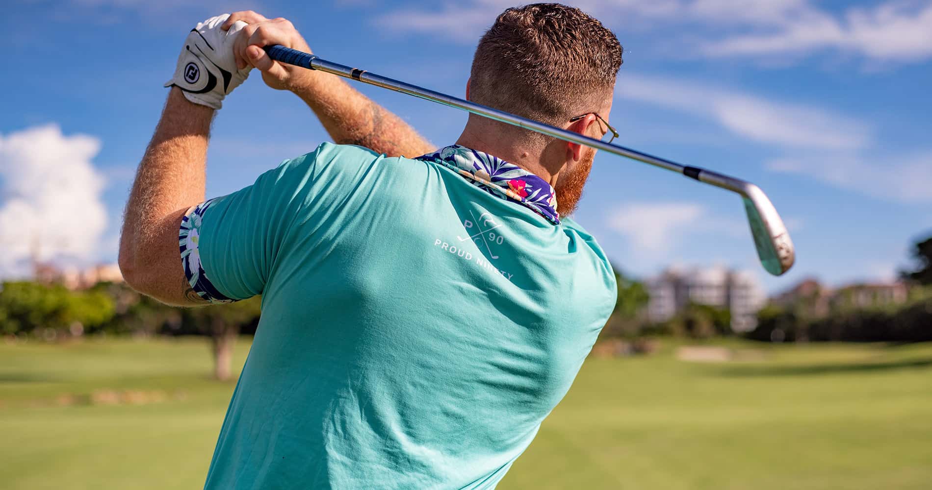 Golfeur en plein swing sur un terrain, ciel bleu en arrière-plan.